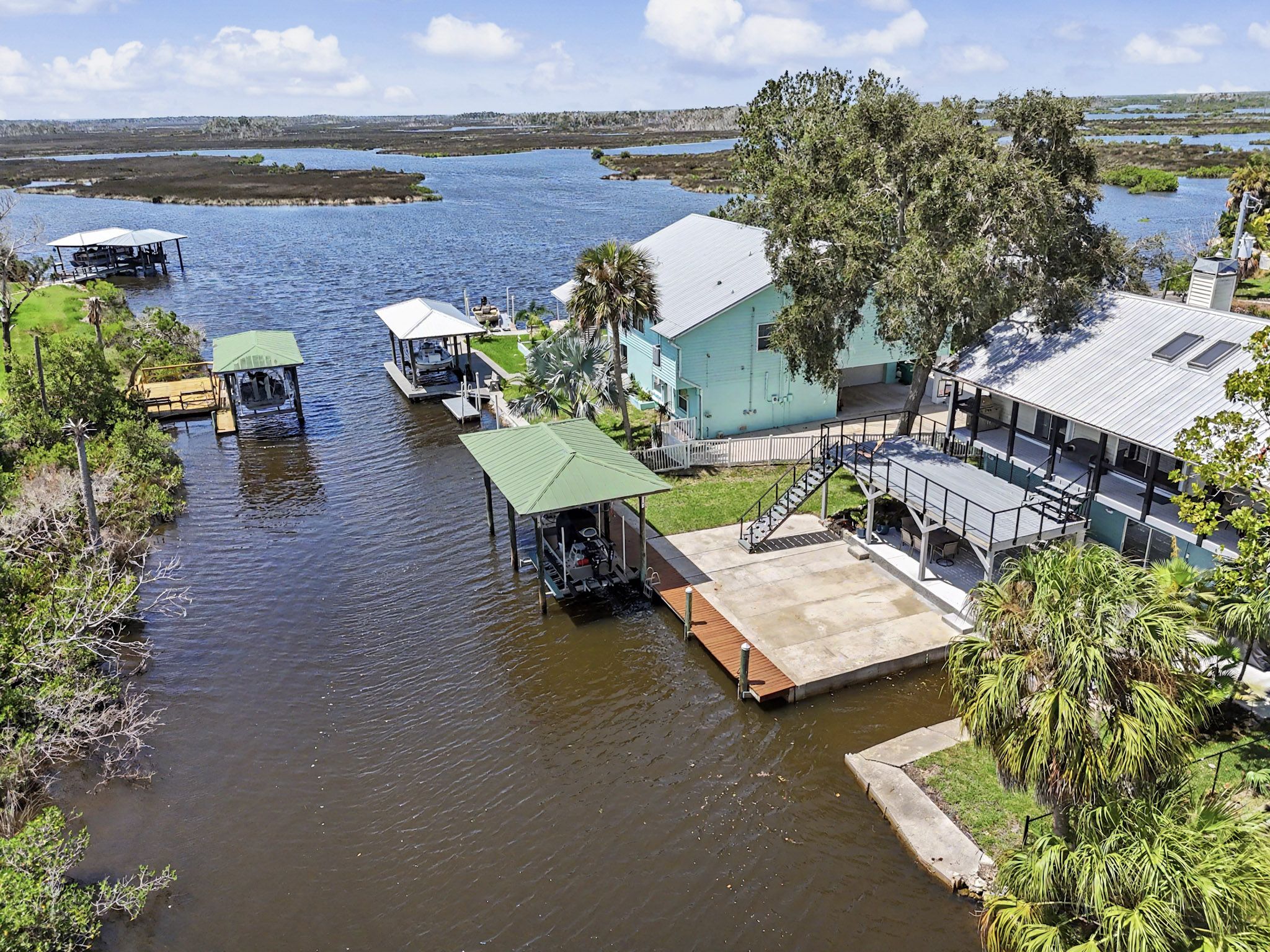 Aerial view over the water toward the house, private dock and neighbouring waterway at The Rusty Hook Riverhouse
